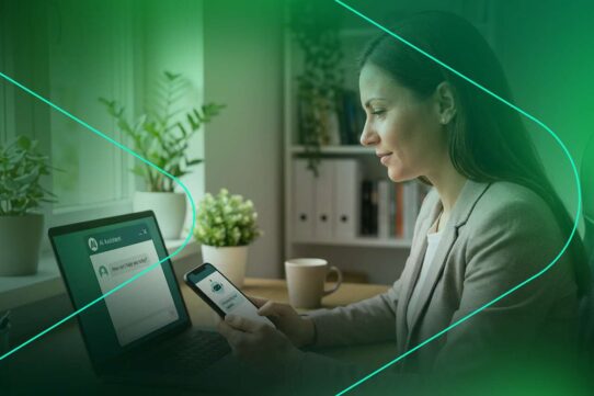 Mulher usando smartphone e laptop em ambiente moderno.