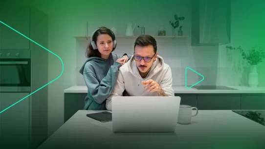 Casal trabalhando juntos em um laptop na cozinha