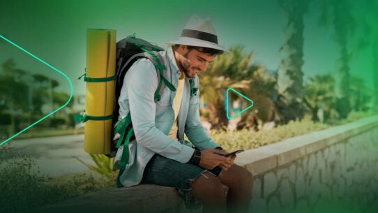 Homem jovem usando celular com mochila de camping