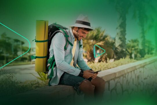 Homem jovem usando celular com mochila de camping