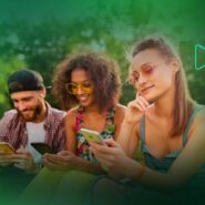 Três amigos usando smartphones ao ar livre