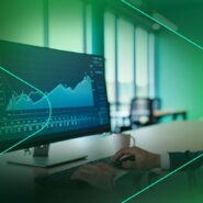 Homem analisando gráficos em monitor de escritório moderno.