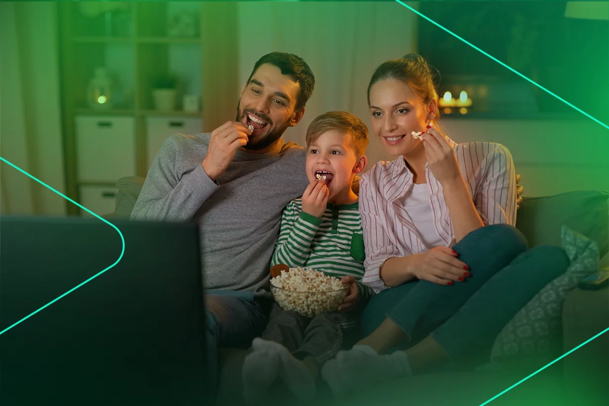 Família assistindo filme comendo pipoca no sofá