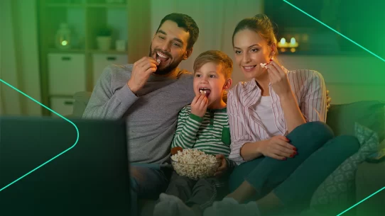 Família assistindo filme comendo pipoca no sofá