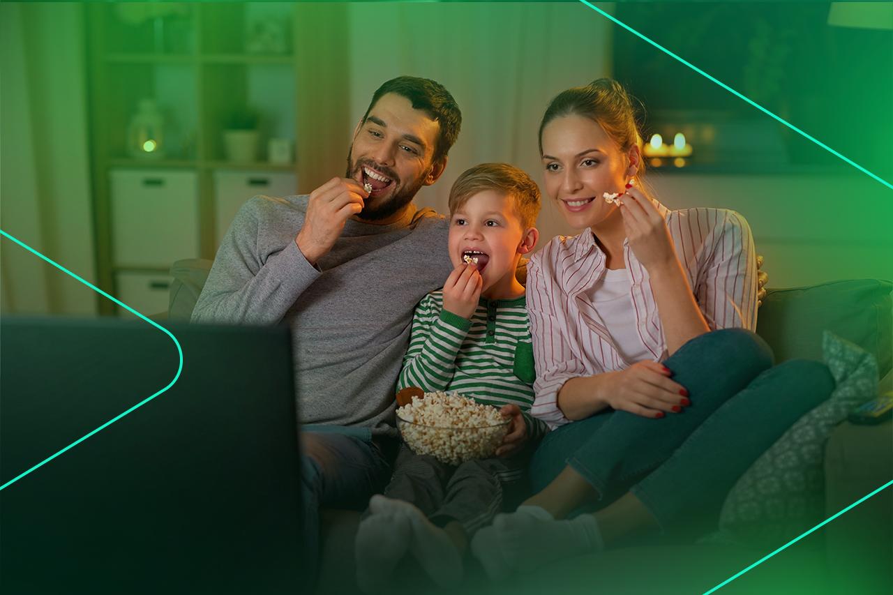 Família assistindo filme comendo pipoca no sofá