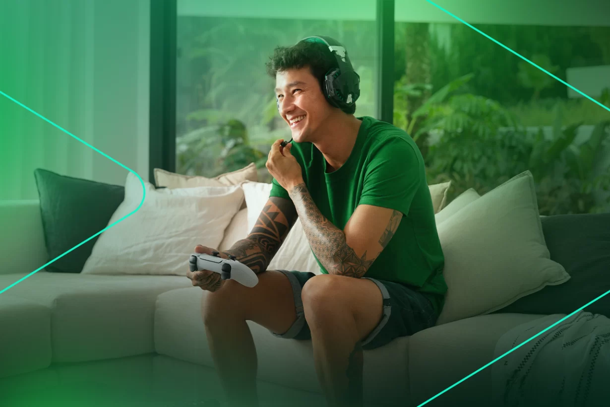 Jovem sorrindo enquanto joga videogame em casa
