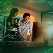 Duas pessoas analisando dados em um computador