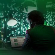 Homem trabalhando em laptop com fundo urbano iluminado