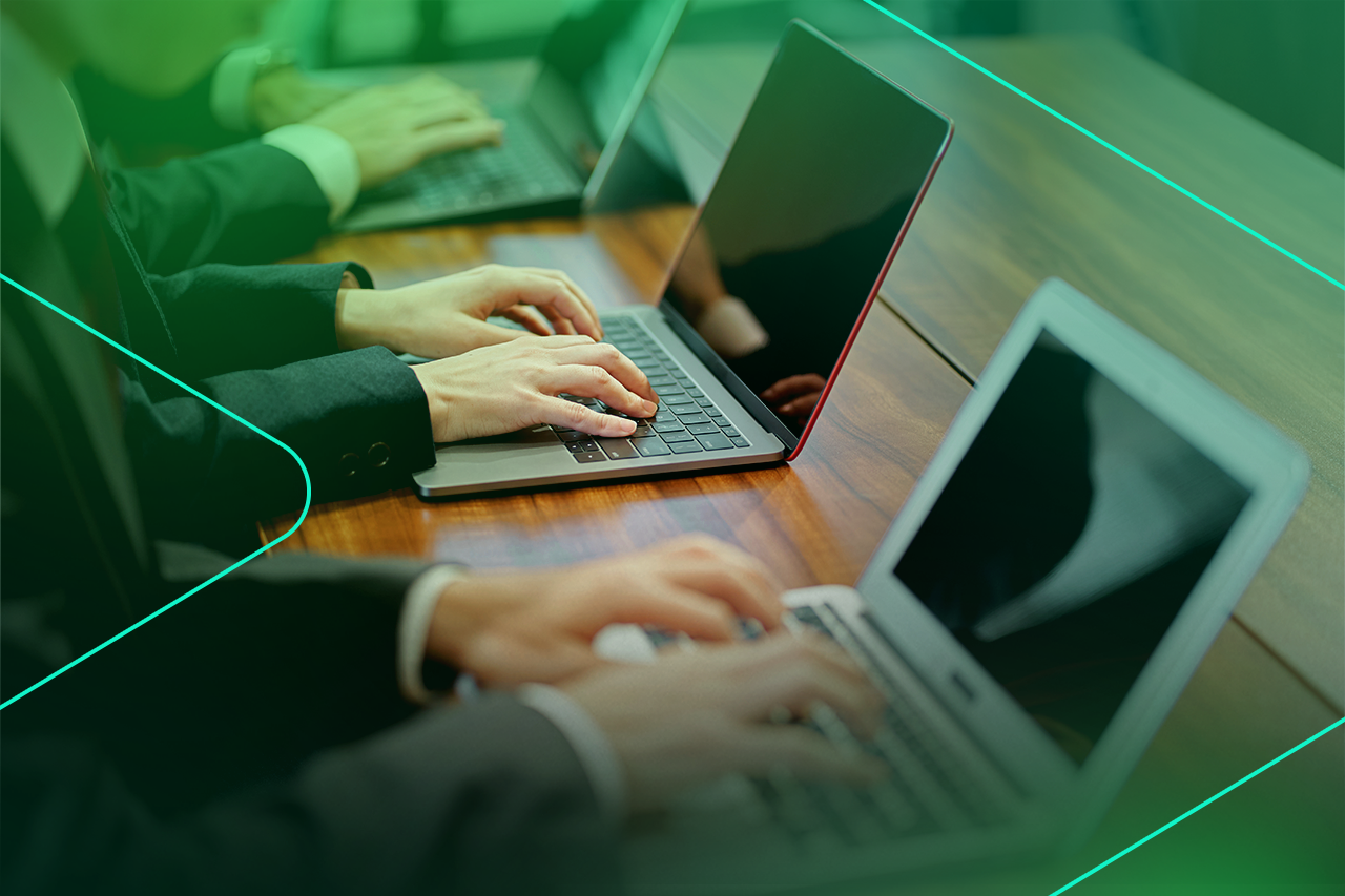 Grupo de pessoas digitando em laptops em uma mesa