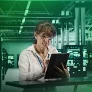 Mulher usando tablet em ambiente tecnológico.