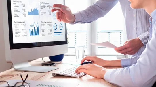 Grupo de pessoas analisando gráficos no computador