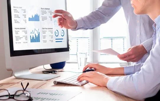 Grupo de pessoas analisando gráficos no computador