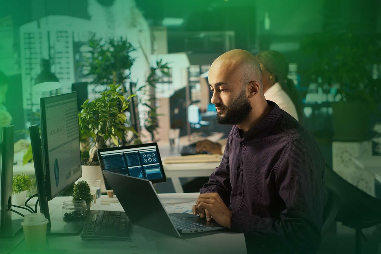 Homem com laptop em escritório moderno e sustentável