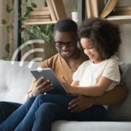 Homem e criança interagindo com um tablet