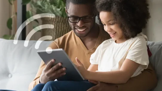 Homem e criança interagindo com um tablet