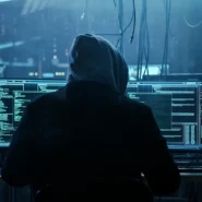 Homem encapuzado interagindo com computadores