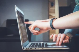 Duas pessoas discutindo sobre algo que está sendo apresentado no notebook