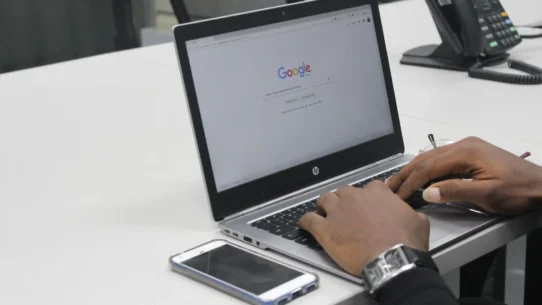 Pessoa interagindo com o notebook, pesquisando na internet