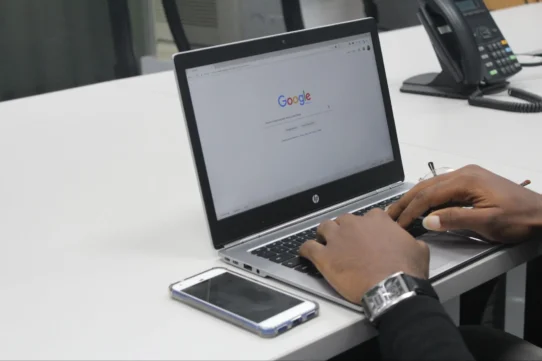 Pessoa interagindo com o notebook, pesquisando na internet