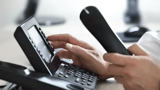 Pessoa atendendo e interagindo com o telefone fixo