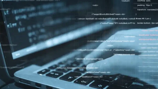 Mãos interagindo com um notebook, em uma tela de desenvolvimento