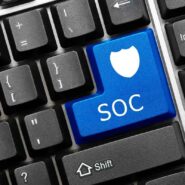 Teclado com a tecla Enter da cor azul, personalizado com a sigla SOC e um escudo.
