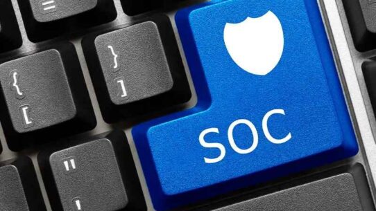 Teclado com a tecla Enter da cor azul, personalizado com a sigla SOC e um escudo.