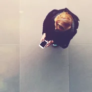 Mulher interagindo ao celular, com o ângulo acima dela.