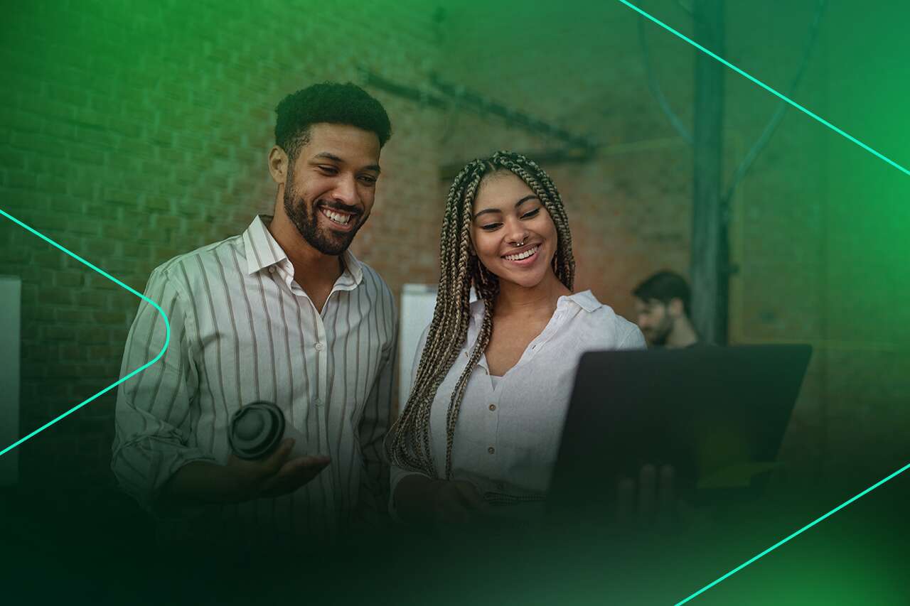 Casal sorridente usando laptop em ambiente descontraído