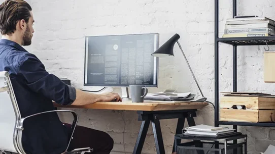 Homem trabalhando ao computador no modelo home office