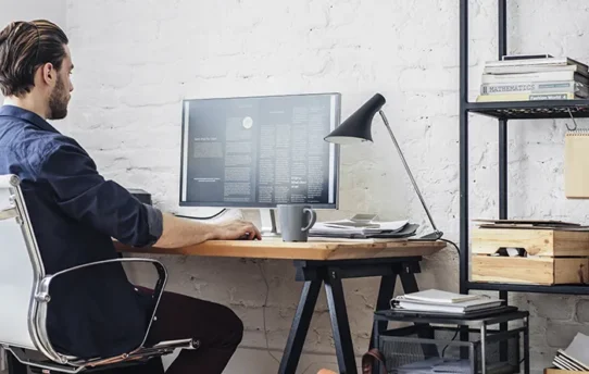 Homem trabalhando ao computador no modelo home office