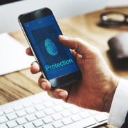 Pessoa interagindo com um telefone, que está exibindo símbolos referentes à proteção (digitais)