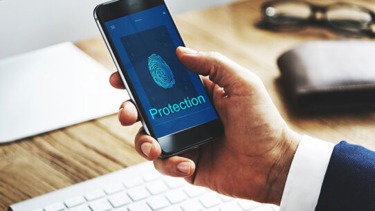 Pessoa interagindo com um telefone, que está exibindo símbolos referentes à proteção (digitais)