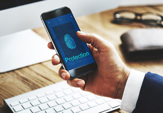 Pessoa interagindo com um telefone, que está exibindo símbolos referentes à proteção (digitais)