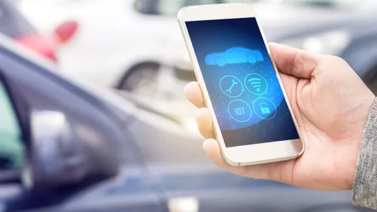 Pessoa utilizando o celular para verificar aspectos de frotas de veículos.