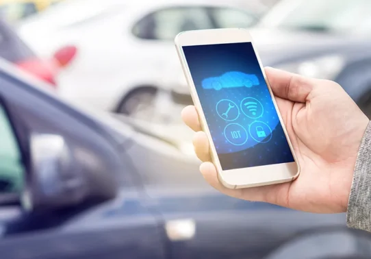 Pessoa utilizando o celular para verificar aspectos de frotas de veículos.