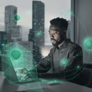 Homem trabalhando em computador com elementos tecnológicos.