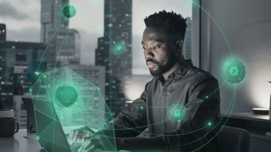 Homem trabalhando em computador com elementos tecnológicos.