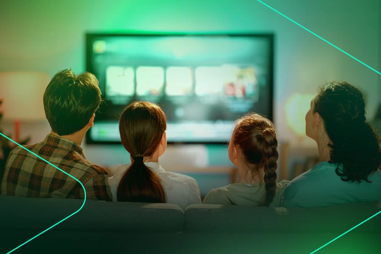 Família assistindo TV juntos em sala iluminada