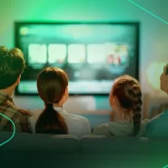 Família assistindo TV juntos em sala iluminada