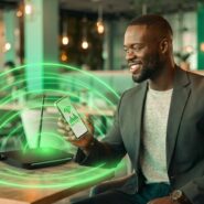 Homem usando smartphone com sinal de Wi-Fi em café
