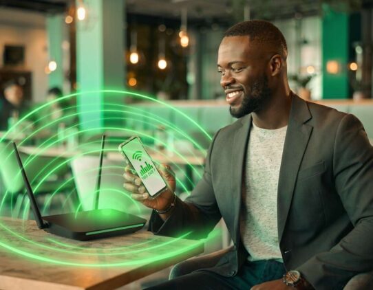 Homem usando smartphone com sinal de Wi-Fi em café