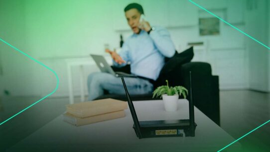Homem usando computador e telefone em casa