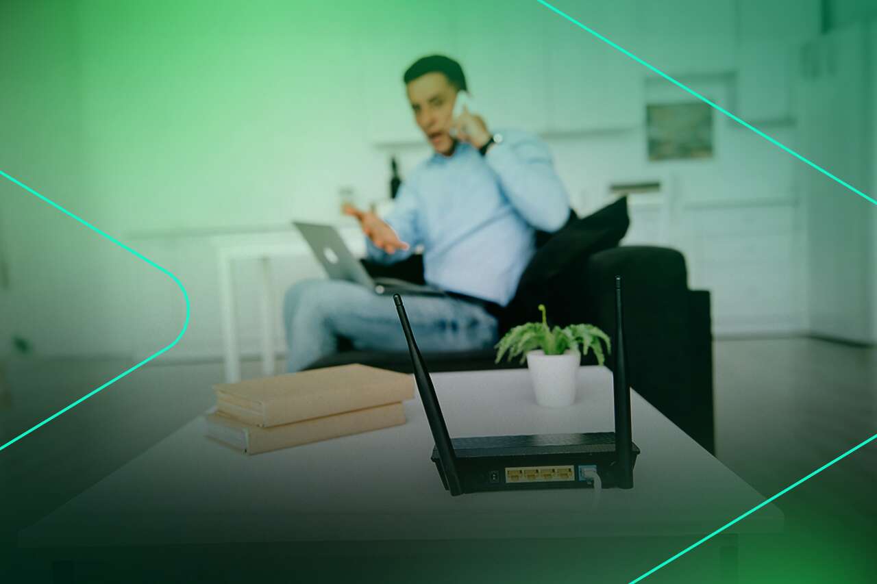 Homem usando computador e telefone em casa