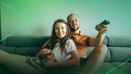 Casal relaxando no sofá assistindo televisão
