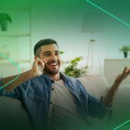 Homem sorridente conversando ao telefone em casa