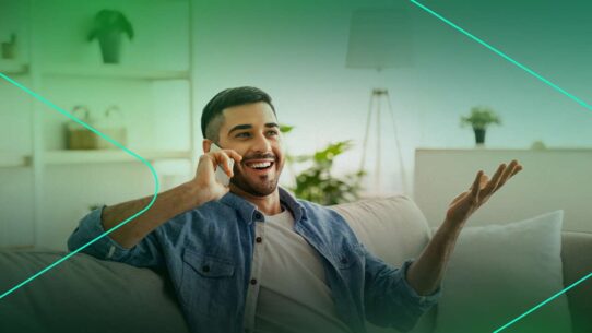 Homem sorridente conversando ao telefone em casa