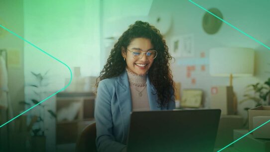 Mulher sorrindo enquanto trabalha no computador
