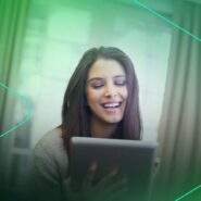 Mulher sorrindo enquanto usa um tablet