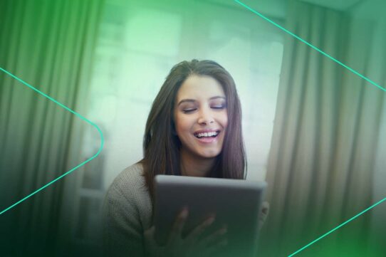 Mulher sorrindo enquanto usa um tablet